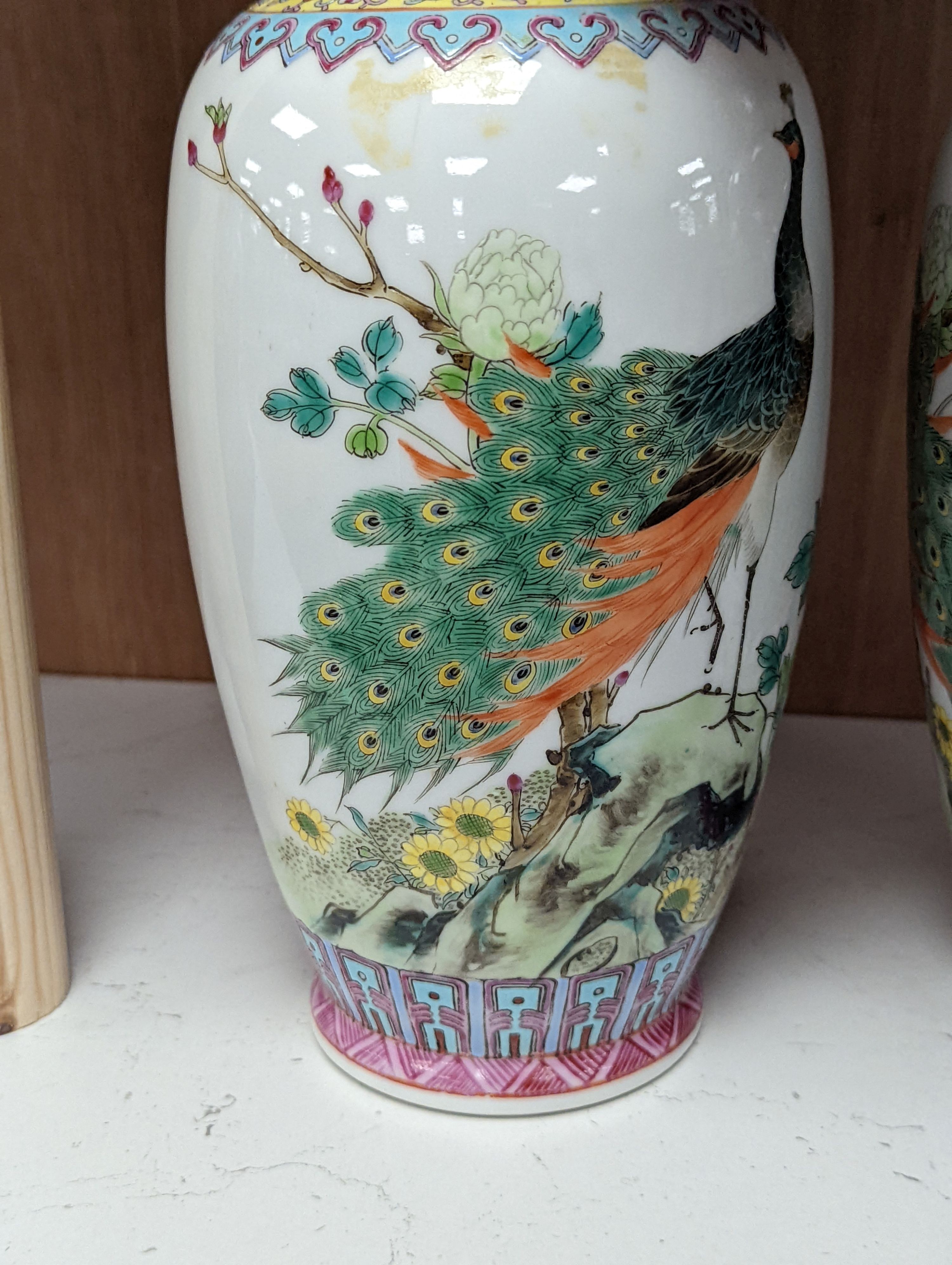 A pair of Chinese famille rose vases decorated with peacocks, 31cm